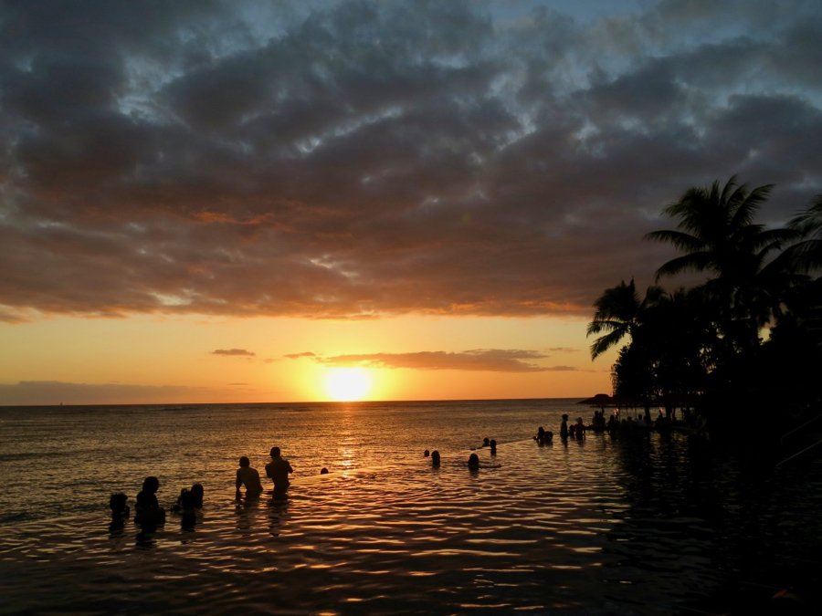 夏威夷瓦胡岛一个无边泳池里的橙色日落。两个人在泳池边拍照——这显然是新冠疫情前的旅行时光。开云体育总入球©开云体育登录入口手机版官网网址KettiWilhelm2020