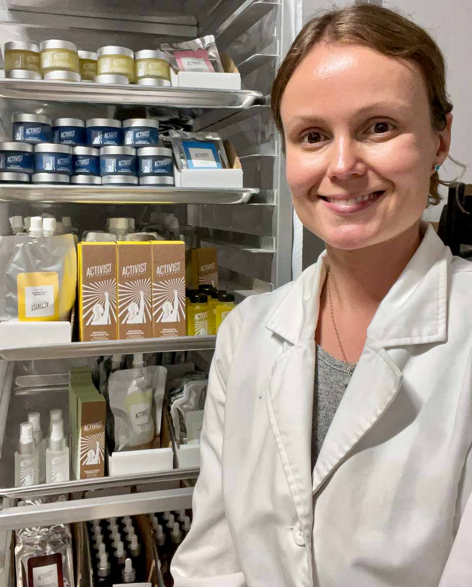活动家护肤品创始人艾莉森·卡拉威穿着白色白大褂在工作室里，她的小公司生产环保护肤品。